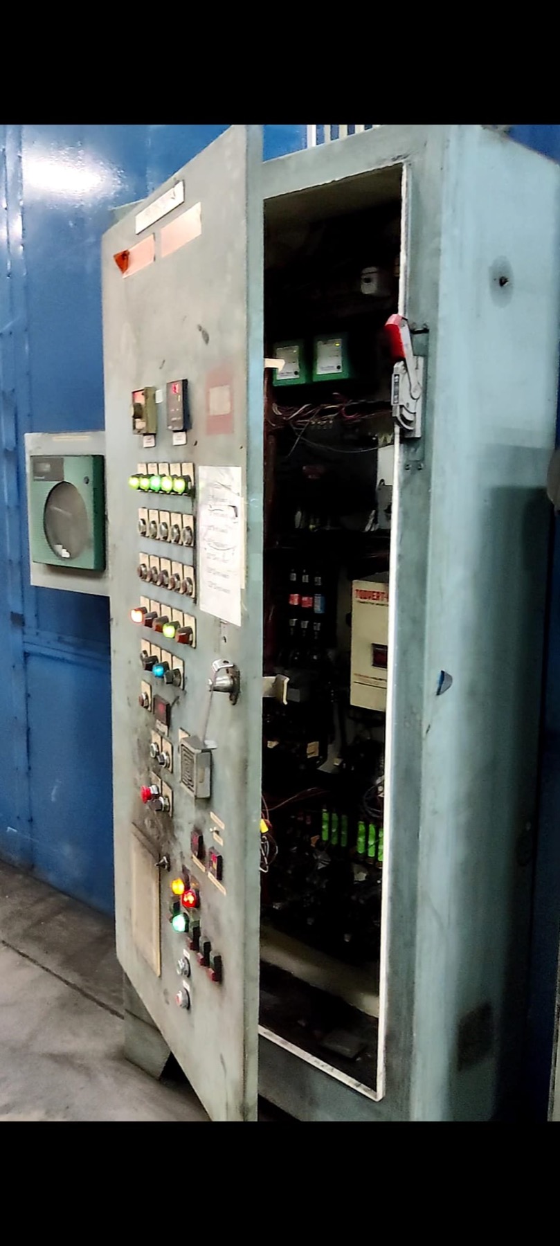 Legacy electrical control cabinet on Line 6 with the door open, showing analog controls and pilot lights